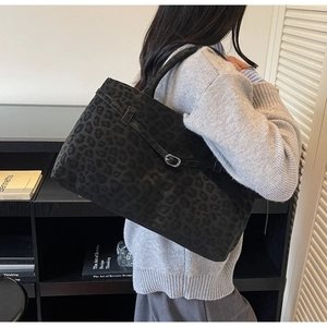 Detail der schwarzen Tote Bag mit Leopardenmuster, Metallschnalle und Wildledertextur