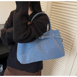 Detail of blue faux suede tote bag featuring leopard print pattern and metal buckle strap
