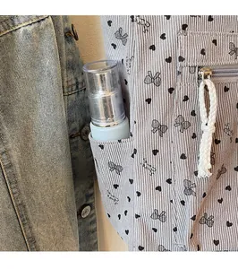 Detail of the corduroy tote bag side pocket holding a skincare spray bottle