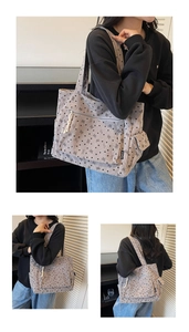 Detail view of corduroy tote bag featuring heart bow prints and white tassel zipper