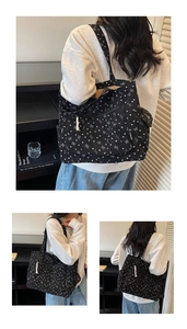 Detail view of black corduroy tote with white heart bow prints and side buckle pocket