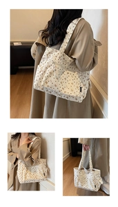 Detailed views of beige corduroy tote bag with brown heart and bow prints in casual use