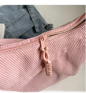 Gros plan du sac en velours côtelé rose avec fermeture éclair et cordon de serrage