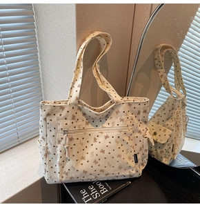 Detail of corduroy tote bag with heart and bow print and practical side storage pockets