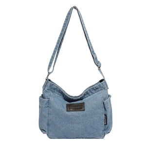 Vintage blue denim canvas crossbody bag with adjustable strap and leather brand label