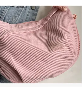 Détail de la texture velours rose et du zip à nœud sur un sac bandoulière croissant