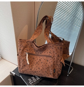 Detail of vintage corduroy tote bag with bow prints, zipper pocket, and side pouch