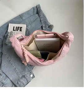 Vue intérieure du sac bandoulière en velours côtelé rose avec grand rangement