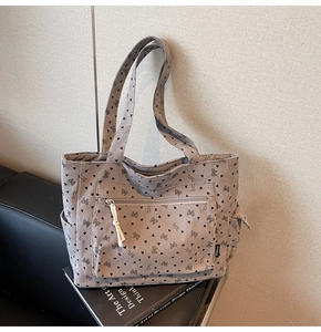 Detail of light grey corduroy tote bag with black heart and bow print and side pocket