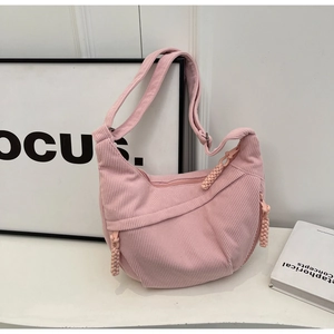 Détail du sac bandoulière croissant en velours côtelé rose avec tirettes tressées