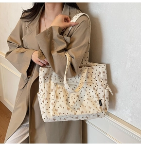 Detail of corduroy tote bag with heart and bow patterns and functional zip pockets