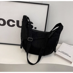 Détail du sac hobo en velours côtelé noir avec large bandoulière et tirette tressée