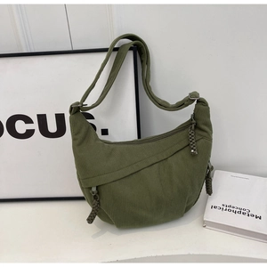 Texture détaillée du sac croissant en velours côtelé vert olive avec tirette tressée