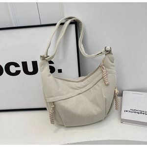 Détail du sac demi-lune en velours côtelé crème avec zip tressé et bandoulière réglable