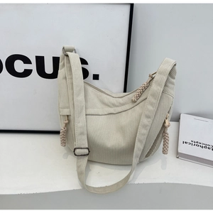 Détail du sac bandoulière croissant en velours côtelé crème avec tirette de zip tissée main