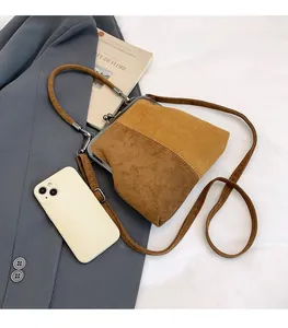 Sac à bandoulière rétro marron, comparaison de taille avec téléphone sur veste grise