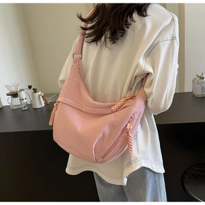Détail du sac croissant en velours côtelé rose avec bandoulière réglable et texture