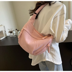 Détail du sac besace en velours côtelé rose montrant la texture douce du tissu