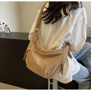 Vue de dos d'un sac bandoulière en velours côtelé marron clair porté dans un décor épuré