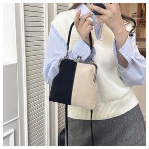 Selfie miroir montrant un sac rétro bicolore avec poignée noire et bandoulière amovible