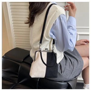 Détail du sac docteur vintage bicolore avec fermoir métallique et bandoulière fine