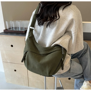Gros plan sur la texture en velours côtelé vert olive et le cordon de fermeture du sac