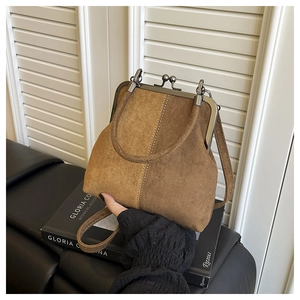 Detail der Vintage-Bügeltasche aus Wildleder mit Metallverschluss und braunem Kontrast