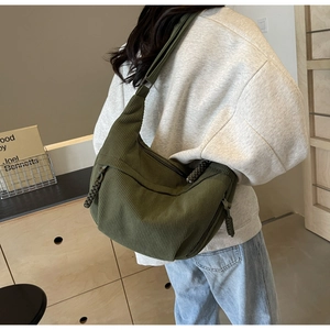 Gros plan du sac bandoulière en velours côtelé vert olive avec tirette de zip tissée