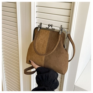 Détail du sac à main rétro en daim bicolore avec fermoir métallique et anse ronde