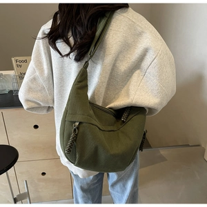 Détail d'un sac hobo en velours côtelé vert olive avec tirette de fermeture tressée