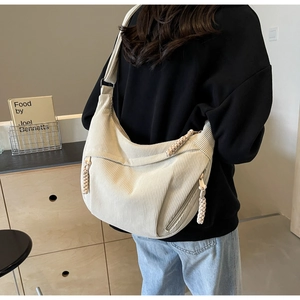 Détail du sac bandoulière en velours côtelé crème avec sangle réglable et tirette tissée