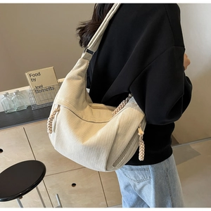 Détail du sac bandoulière en velours côtelé crème avec tirette de fermeture tressée