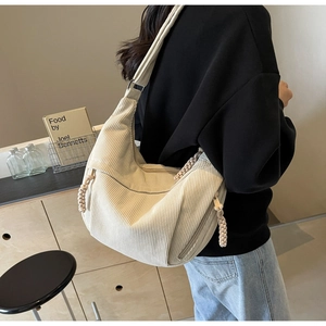 Gros plan détaillé du sac hobo en velours côtelé beige avec tirette de fermeture tressée