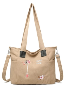 Detail of khaki corduroy tote bag with floral embroidery and adjustable strap