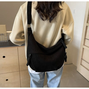 Détail du sac bandoulière en velours côtelé noir avec bandoulière réglable sur le dos