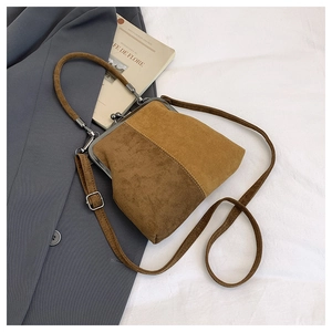Macro shot of brown suede vintage frame bag with metal ring handle and ball clasp