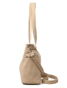 Detail of beige corduroy tote bag showing side pocket and adjustable shoulder strap
