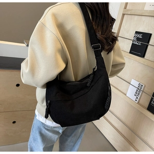Détail du sac bandoulière en velours côtelé noir avec texture et sangle ajustable