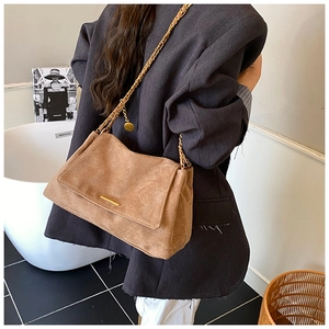 Détail d'un grand sac cabas marron en suédine avec bandoulière chaîne et finition dorée