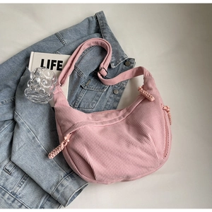 Détail du sac demi-lune en velours côtelé rose avec bandoulière et poches zippées