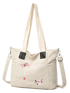 Detail of corduroy tote bag with pink floral embroidery and adjustable strap