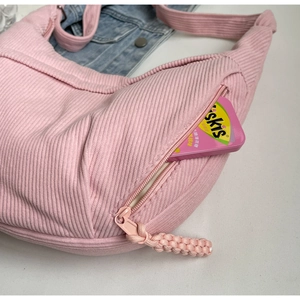 Gros plan sur le velours côtelé rose du sac lune avec poche zippée et texture fine