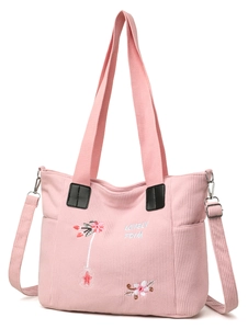 Detail of pink corduroy tote bag featuring floral embroidery and textured fabric