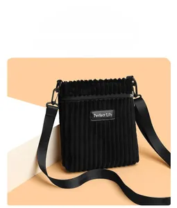 Detail of black corduroy shoulder bag showing vertical texture and Perfect Lily label