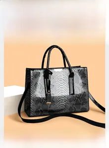 Detail van de slangenprint shopper met glanzende afwerking en gouden metalen logo