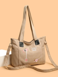 Detail of khaki corduroy tote bag showing floral embroidery and adjustable strap
