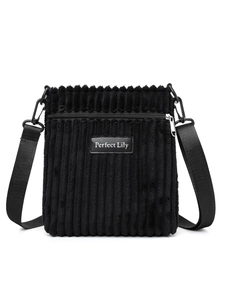 Close-up of black corduroy shoulder bag featuring zip pocket and metal carabiner hook