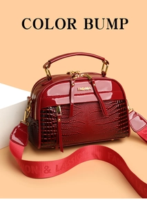 Détail du sac à main en cuir croco rouge avec panneau verni et finitions dorées