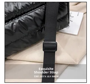 Detail of adjustable black nylon shoulder strap on a quilted puffer tote bag