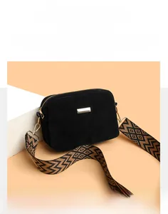 Close-up of black frosted fabric crossbody bag with chevron patterned canvas shoulder strap